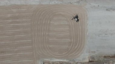 Drone videosu bir traktör cassava kurutma sahasına cassava yayıyor. Cassava un hazırlama süreci