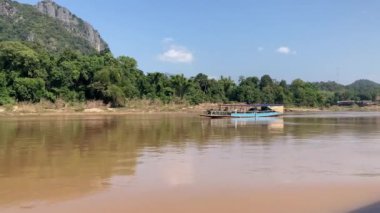 Mekong Nehri boyunca Laos 'ta tekne taşımacılığı, köyleri birbirine bağlamak, malları taşımak ve manzaralı turlar sunmak için gereklidir. 4k video kaydı