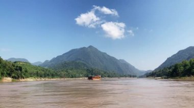Mekong Nehri boyunca Laos 'ta tekne taşımacılığı, köyleri birbirine bağlamak, malları taşımak ve manzaralı turlar sunmak için gereklidir. 4k video kaydı
