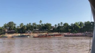 Mekong Nehri boyunca Laos 'ta tekne taşımacılığı, köyleri birbirine bağlamak, malları taşımak ve manzaralı turlar sunmak için gereklidir. 4k video kaydı