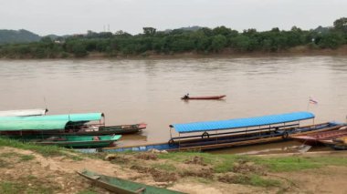 Mekong Nehri boyunca Laos 'ta tekne taşımacılığı, köyleri birbirine bağlamak, malları taşımak ve manzaralı turlar sunmak için gereklidir. 4k video kaydı