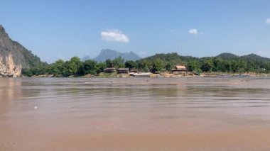 Mekong Nehri boyunca Laos 'ta tekne taşımacılığı, köyleri birbirine bağlamak, malları taşımak ve manzaralı turlar sunmak için gereklidir. 4k video kaydı