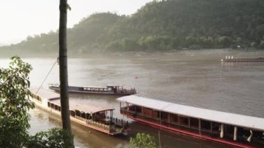 Mekong Nehri boyunca Laos 'ta tekne taşımacılığı, köyleri birbirine bağlamak, malları taşımak ve manzaralı turlar sunmak için gereklidir. 4k video kaydı