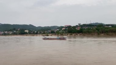 Mekong Nehri boyunca Laos 'ta tekne taşımacılığı, köyleri birbirine bağlamak, malları taşımak ve manzaralı turlar sunmak için gereklidir. 4k video kaydı