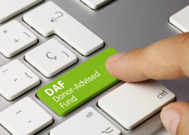 DAF Donor-Advised Fund Written on Green Key of Metallic Keyboard. Finger pressing key.