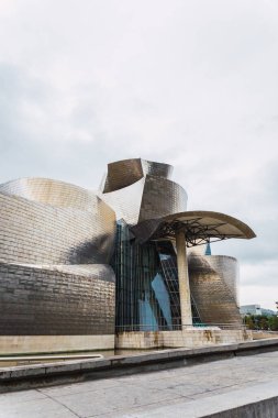 Bilbao, İspanya - Eylül 2022: Bulutlu bir günde Bilbao 'daki Guggenheim Müzesi. Guggenheim Müzesi Bilbao modern ve çağdaş sanat müzesidir.