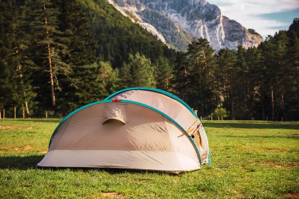 Closeup of a tent with amazing landscape views of forest and mountains. Camping holiday and outdoor summer vacation. Lifestyle concept