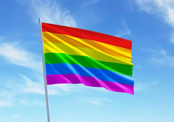 Pride rainbow flag waving in a blue sky background for LGBTQIA+ Pride month, sexuality freedom, love diversity celebration and the fight for human rights in 3D illustration