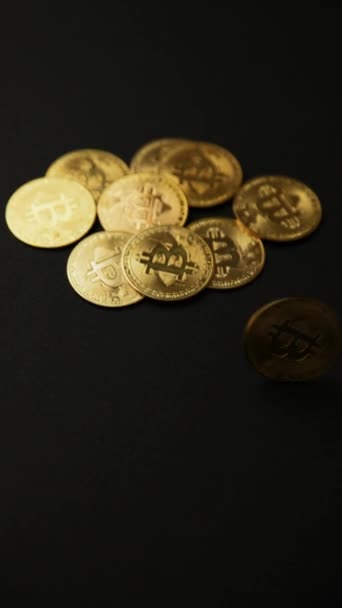 黒い背景に回転するビットコインのゴールデンコインのクローズアップ 垂直ショット ブルーシュBtc 仮想通貨 2P2取引所 ブロックチェーンコンセプト — ストック動画