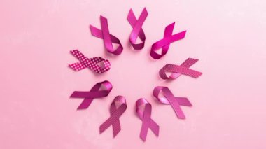 Göğüs Kanseri Farkındalığı Ayı ve Dünya Kanser Günü için fotokopi alanı olan pembe bir zemin üzerinde pembe kurdeleler.