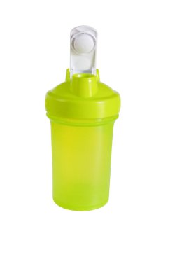 Beyaz zemin üzerinde metalik top olan boş yeşil titreşim şişesi.