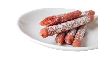 Beyaz arka planda pişirilmiş salam çubukları veya füme sosis..