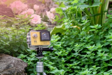 Bahçedeki kayanın üzerinde su geçirmez çantalı aksiyon kamerası..