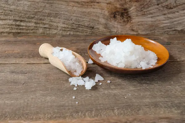 Kepçeli ahşap tabakta deniz tuzu. Sağlıklı yaşam tarzı kavramı.
