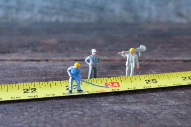 Oyuncak model inşaat işçileri sarı şeritte.