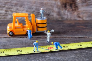 Oyuncak model inşaat işçileri sarı şeritte.