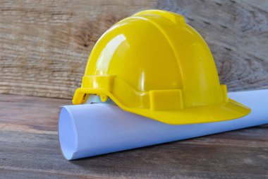 Mimar ruloları ve kaskı masanın üzerine çizer..