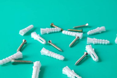 Arkaplanda plastik çapa ve cıvatalar, inşaat aracı.