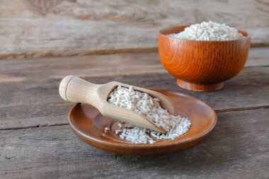 Tabaktaki pirinç yığını ve masada tahta kaşık..