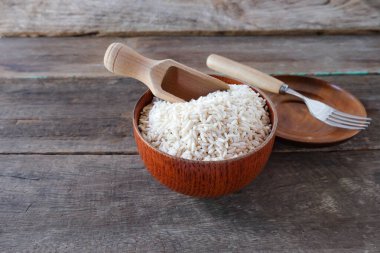 Tabaktaki pirinç yığını ve masada tahta kaşık..