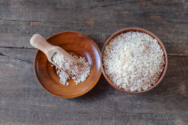 Tabaktaki pirinç yığını ve masada tahta kaşık..