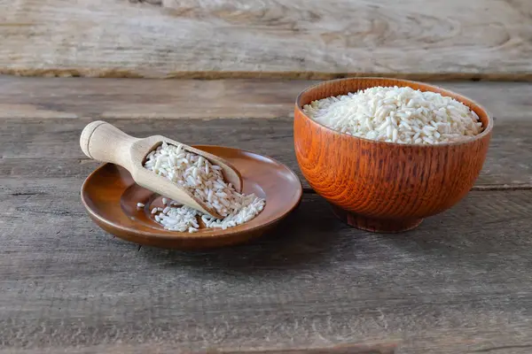 Tabaktaki pirinç yığını ve masada tahta kaşık..