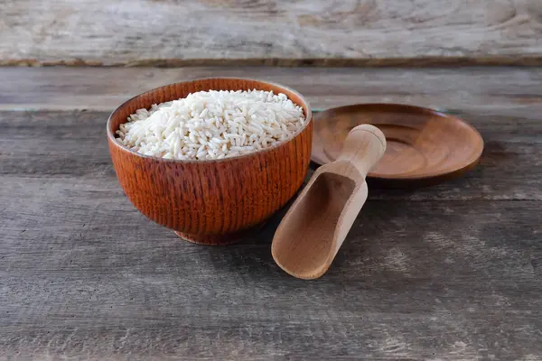 Tabaktaki pirinç yığını ve masada tahta kaşık..