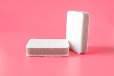 Renk arkaplanında iki temizlik süngeri.