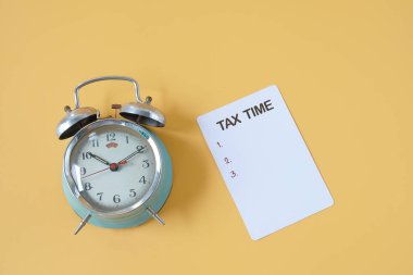 Üzerinde çan olan eski çalar saat, üzerinde kağıt ve vergi saatleri var..