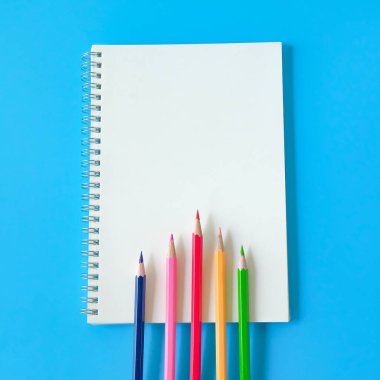 Arka planda dizüstü bilgisayar ve renkli kalem görünümü.