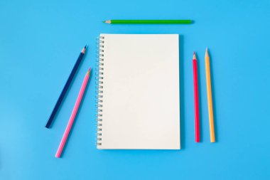 Arka planda dizüstü bilgisayar ve renkli kalem görünümü.