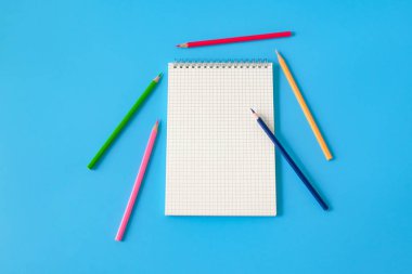 Arka planda dizüstü bilgisayar ve renkli kalem görünümü.