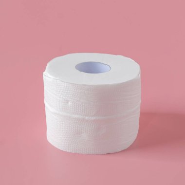 Pembe arka planda duran tuvalet kağıdı ruloları.