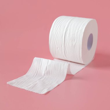 Pembe arka planda duran tuvalet kağıdı ruloları.