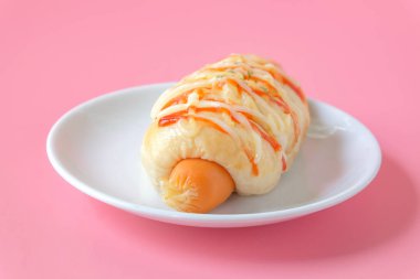 Sosisli ekmek ve peynirli sos. Stüdyo çekimi renk arkaplanı.