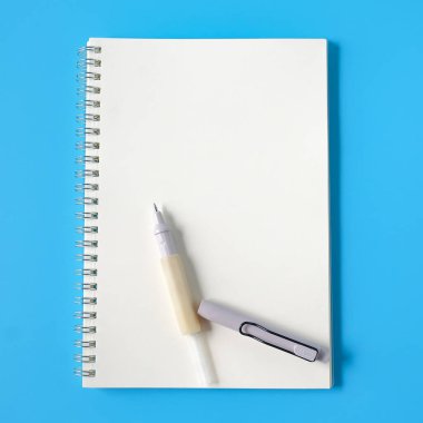 Arka planda defter ve kırık kalem.