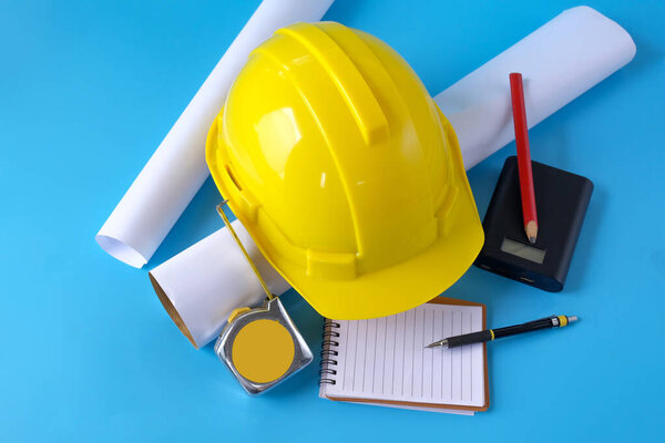 Шлем и рулетка на заднем плане, работа над проектом строительства.