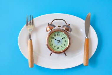 Çatal ve bıçak ve alarm saati, sağlık konsepti yeme zamanı..