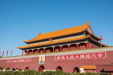Ziyaretçiler Pekin 'in tarihi kalbi Tiananmen Meydanı' ndaki açık mavi gökyüzüne karşı kırmızı bayrakları takdir ediyorlar..