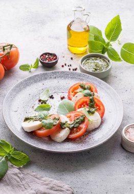 Fesleğenli, pesto soslu ve zeytinyağlı mozzarella ile domates. Yüksek kalite fotoğraf