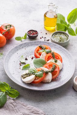 Fesleğenli, pesto soslu ve zeytinyağlı mozzarella ile domates. Yüksek kalite fotoğraf