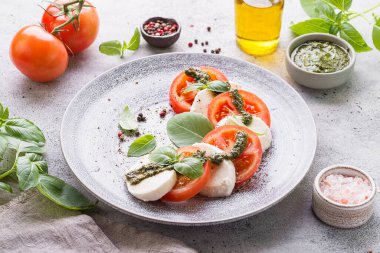 Fesleğenli, pesto soslu ve zeytinyağlı mozzarella ile domates. Yüksek kalite fotoğraf
