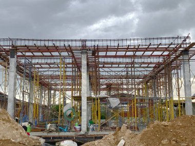 Yeni ev yapım aşamasında. Bulutlarda işçi yok. Beton sütunlar ve iskeleler görünüyordu..