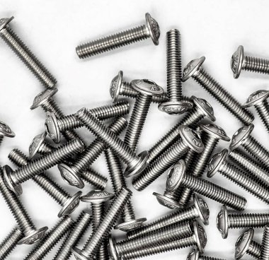 Beyaz yansıtıcı arka planda birçok vida DIN 7380F 