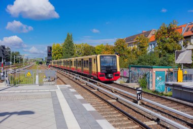 Berlin 'in yeni Berlin S-Bahn' ı şehir merkezinden Gruenau 'ya doğru ilerliyor. 483 / 484 numaralı tren sınıfı, Baumschulenweg durağı yakınlarındaki yenilenmiş raylar üzerindeki modern Berlin treni.