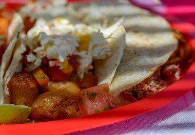Mexican Baja fish tacos in Todos Santos with fresh sauce on colorful background. Tacos of scallop, marlin, white fis and shrimp with habanero salsa