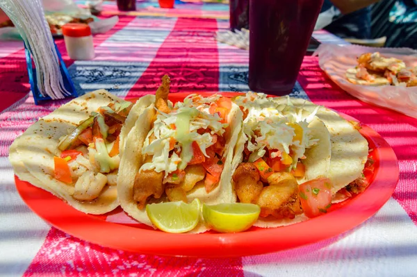 Mexican Baja fish tacos in Todos Santos with fresh sauce on colorful background. Tacos of scallop, marlin, white fis and shrimp with habanero salsa