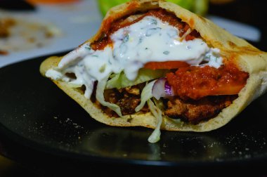 Tavuk donör kebap, ev yapımı pita ekmekli Türk usulü kebap sandviç ve taze salata ve ev yapımı acı biber sosu ve sarımsaklı yoğurt sosu..