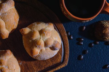 Geleneksel ölü Meksika ekmeği, Pan de Muerto olarak bilinir, portakalla tatlandırılmış, tahta arka planda Meksika cafe de olla ile servis edilir. Geleneksel olarak Ölüler Günü 'nde sunak olarak yapılır..