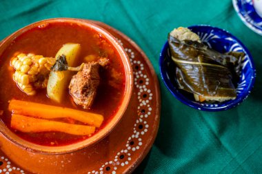 Churipo, traditional beef stew from Michoacan, Mexico, accompanied on the table by a corunda, a type of corn tamal made with ashes. clipart